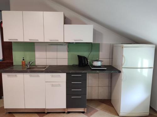 a kitchen with white cabinets and a white refrigerator at Montenegro Colors in Kamenari
