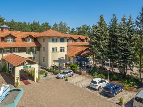 a large building with cars parked in a parking lot at Ferien Hotel Spree-Neisse in Neuhausen