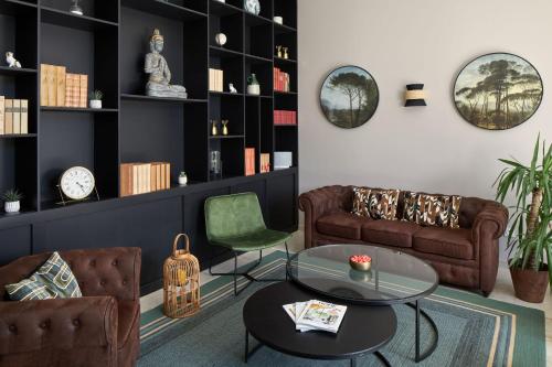 a living room with a couch and a table at Hôtel Saint-Alban in Nézignan-lʼÉvêque
