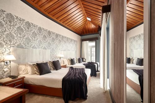 een slaapkamer met 2 bedden in een kamer bij Galeria Suite Hotel in Aveiro