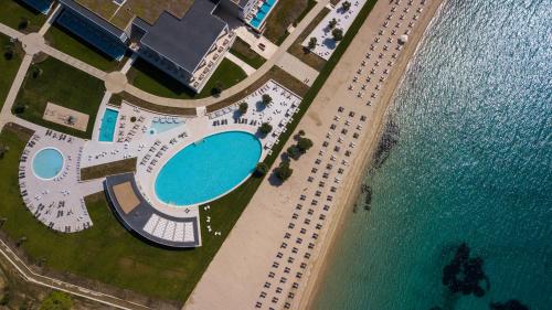 an overhead view of a pool and parking lot next to the water at Ammoa Luxury Hotel & Spa Resort in Nikiti