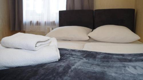 a bed with two pillows and towels on it at Pokoje Żabi Staw in Mikołajki