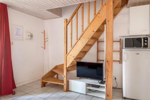 Il comprend un salon doté d'une télévision et d'un escalier en bois. dans l'établissement Maison en plein cœur du centre historique de Pornic, à Pornic