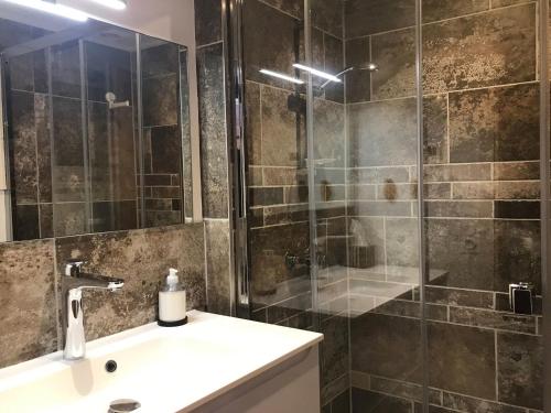a bathroom with a shower with a sink and a mirror at Appartement La Clusaz, 4 pièces, 6 personnes - FR-1-304-214 in La Clusaz