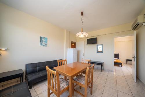 a dining room with a table and chairs and a couch at Lorenzo House Apartments in Lassi