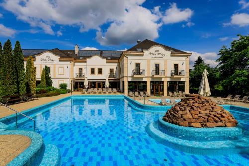 uma grande piscina em frente a uma grande casa em Hotel Villa Völgy Wellness & Konferencia em Eger