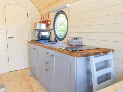 a kitchen in a tiny house with a sink and a mirror at Apple Pod in Arundel