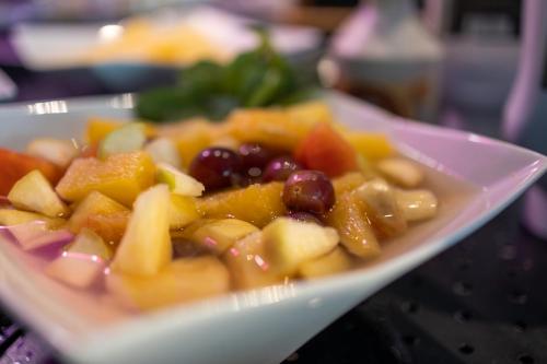 a plate of fruits and vegetables on a table at Hôtel restaurant Kyriad Fréjus in Fréjus