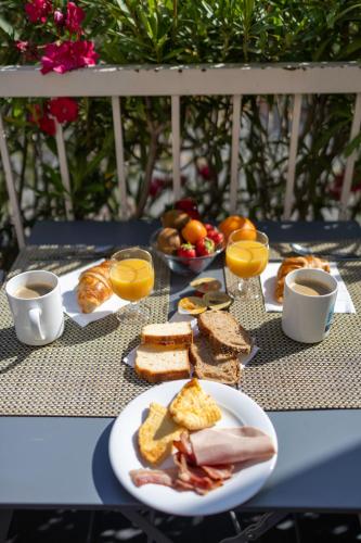 a table topped with plates of breakfast foods and coffee at Hôtel restaurant Kyriad Fréjus in Fréjus