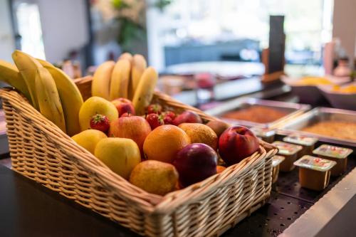 a basket of fruit sitting on a counter at Hôtel restaurant Kyriad Fréjus in Fréjus