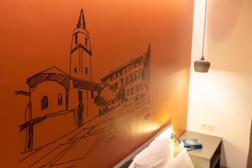 a drawing of a church on the wall of a bedroom at Hôtel restaurant Kyriad Fréjus in Fréjus