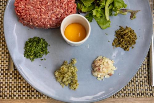 a plate of food with meat and vegetables and sauce at Hôtel restaurant Kyriad Fréjus in Fréjus