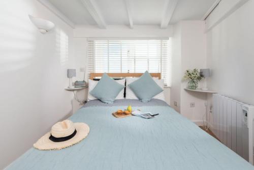 a bedroom with a bed with a hat and shoes on it at Nutshell, Marazion in Marazion