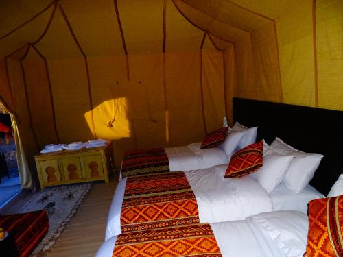 a bedroom with two beds in a tent at Camel Luxury Camp in Merzouga