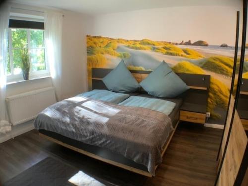 a bedroom with a bed with a painting on the wall at Stadtquartier 2 OG in Bredstedt