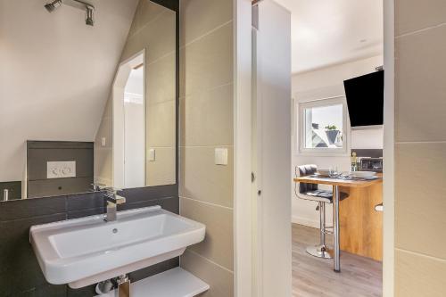a bathroom with a white sink and a desk at Le Sémaphore de Trézien in Plouarzel