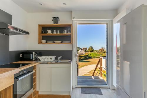 a kitchen with a door leading to a patio at Le Sémaphore de Trézien in Plouarzel
