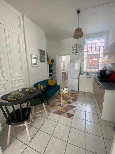 Il dispose d'une cuisine et d'un salon avec une table et un réfrigérateur. dans l'établissement l'Emeraude de Calais - Confort et central, à Calais