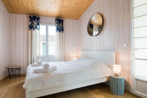 a bedroom with a white bed and a mirror at "MORANDE" grande maison avec Piscine Chauffée in La Noue