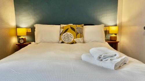 a bedroom with a bed with towels on it at Greystoke House in Keswick