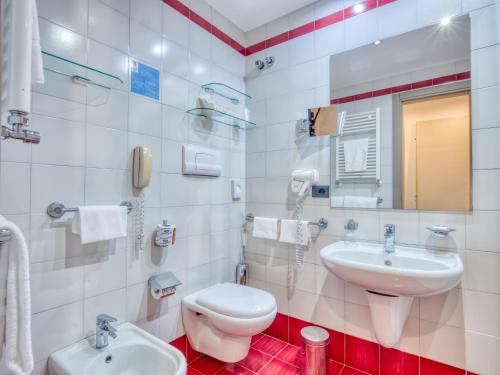 a white bathroom with a sink and a toilet at Hotel Antares in Letojanni
