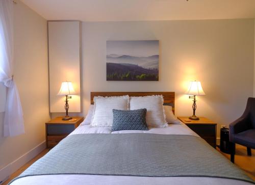 a bedroom with a large bed with two lamps at Le Pimbina in Mont-Tremblant