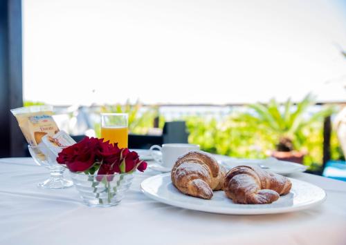 a table with a plate of croissants and roses at Il Poggio Veronica in San Nicola
