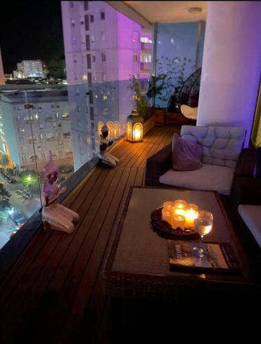 a living room with a view of a balcony with candles at Luxury Ocean Spa Plaza Private Large 1 bed apartment in Gibraltar