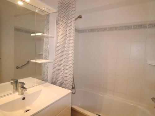 une salle de bain avec un lavabo, une baignoire et une douche dans l'établissement Appartement à Sète avec piscine, terrasse et vue mer - FR-1-472A-228, à Sète