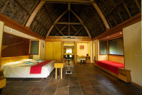 a bedroom with a large bed and a table at Maitai Lapita Village Huahine in Fare
