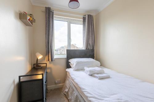 um quarto com uma cama com lençóis brancos e uma janela em Hullidays East Modern Detached 3 Bed House em Hull
