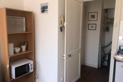 a small room with a microwave and a door at terrasse centre ville in La Rochelle