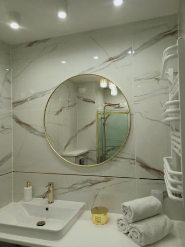 a white bathroom with a sink and a mirror at Apartament Letnicka, Nowy, 950m od morza in Gdańsk