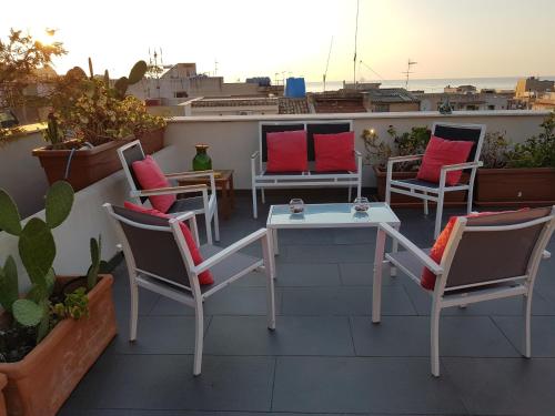 a patio with chairs and tables on a roof at Malusi B&B in Palermo