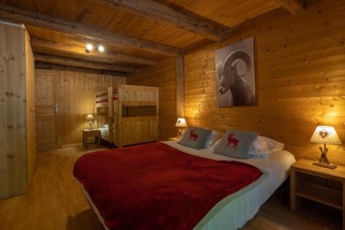 ein Schlafzimmer mit einem Bett in einem Blockhaus in der Unterkunft Ferme de Faustine 2 - piscine in Saint-Gervais-les-Bains