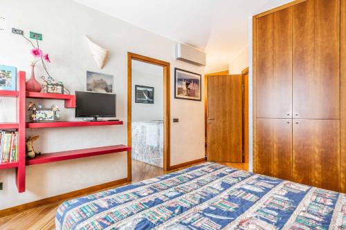 - une chambre avec un lit, une télévision et des étagères dans l'établissement Residenza il Ciliegio, à Busto Arsizio