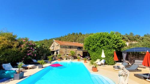 una gran piscina en un patio con una casa en La Bergerie Du Moulin - Maison pour adultes uniquement, en Taradeau