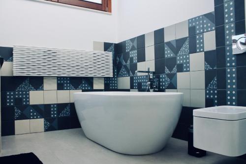 a bathroom with a tub and a toilet in it at Di Rosa Apartment in Avola