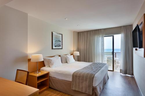 a hotel room with a bed and a view of the ocean at Windsor Palace Copacabana in Rio de Janeiro