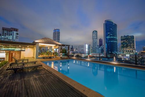 a swimming pool with a city skyline in the background at The Grand Sathorn in Bangkok