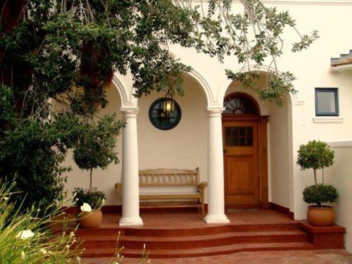 una veranda con panchina e porta in legno di The Walden Suites a Città del Capo