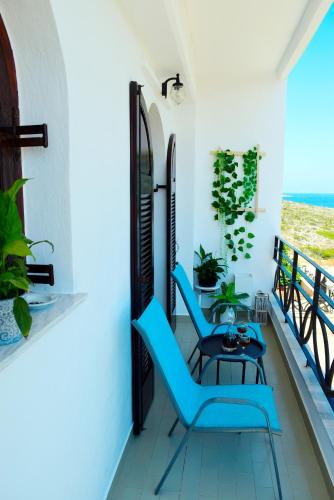 a balcony with two blue chairs and a table at Magnificent sea view,clean and bright apartments in Kalathas