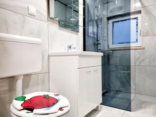 a bathroom with a toilet with an apple on the seat at Villa Art House Krk in Krk