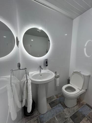 a bathroom with a sink and a toilet and a mirror at Apartments Tumanyan in Yerevan