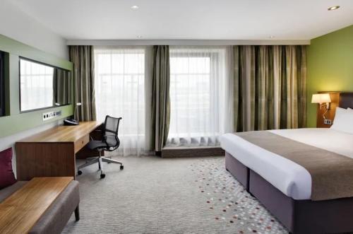 Cette chambre comprend un lit et un bureau. dans l'établissement Holiday Inn Bristol City Centre, an IHG Hotel, à Bristol