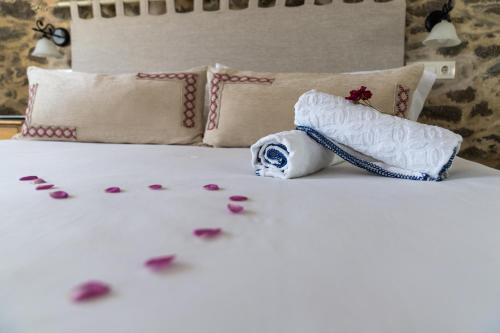 a bed with pink petals on it and flowers on the bed at Casa das Fiadeiras de Nemiña con Jacuzzi in Nemiña