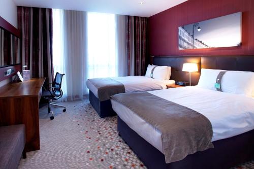 a hotel room with two beds and a desk at Holiday Inn Bristol City Centre by IHG in Bristol