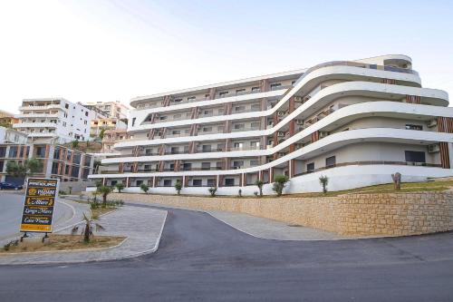 ein großes weißes Gebäude vor einer Straße in der Unterkunft Allure Apartments in Ulcinj