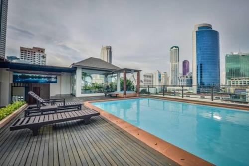 a large swimming pool on a building with a city skyline at The Grand Sathorn in Bangkok