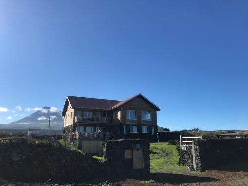 a house on a hill with a mountain in the background at Casa-do-Mar in Madalena